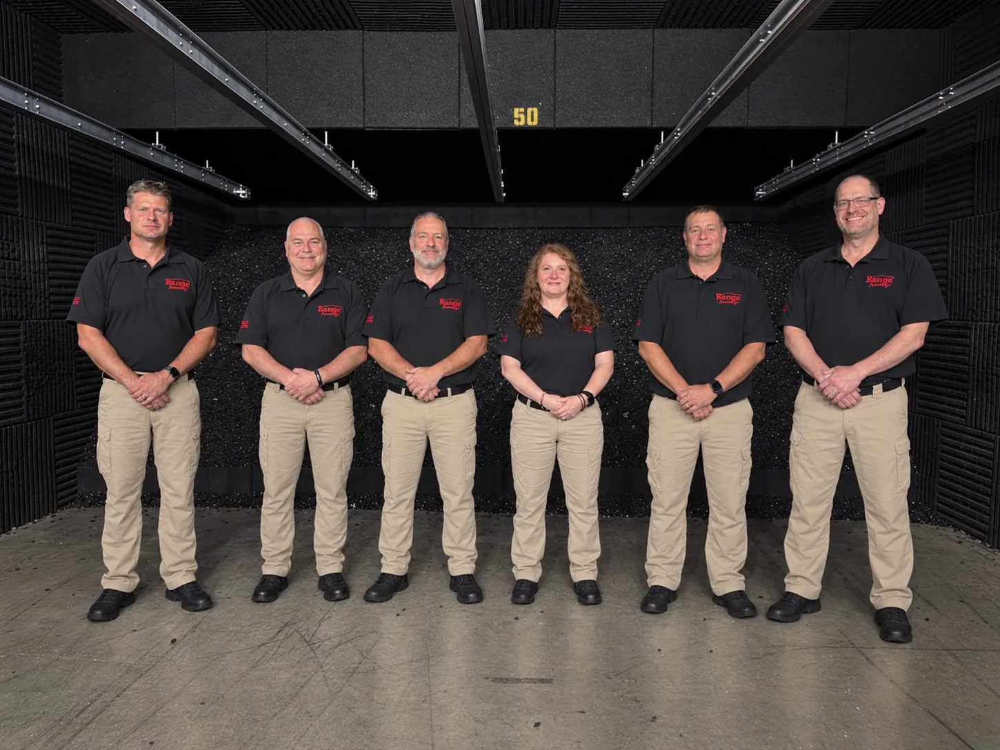 The full Range Academy instructor team together inside a shooting bay